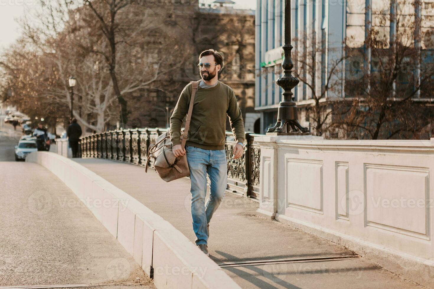 hipster man walking in street with bag photo