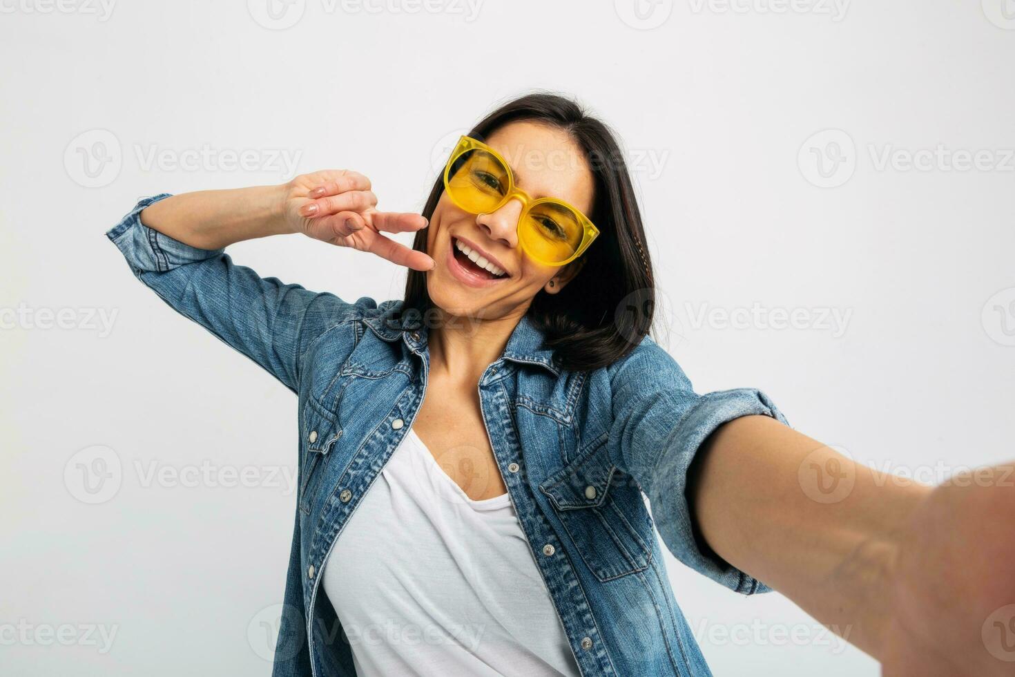 attractive woman dressed jeans and denim shirt wearing yellow sunglasses photo