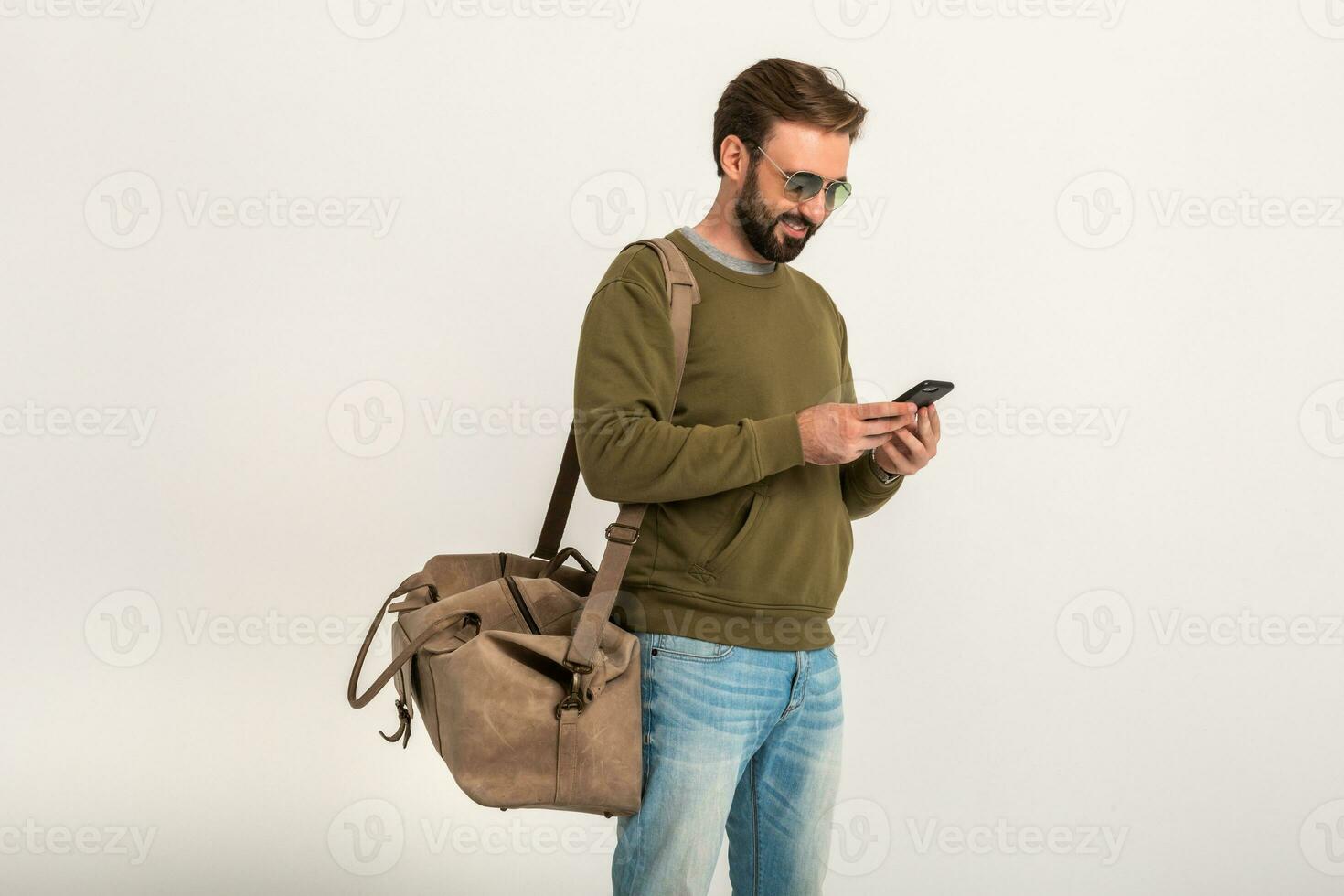 atractivo elegante hombre viajero en pie con bolso foto