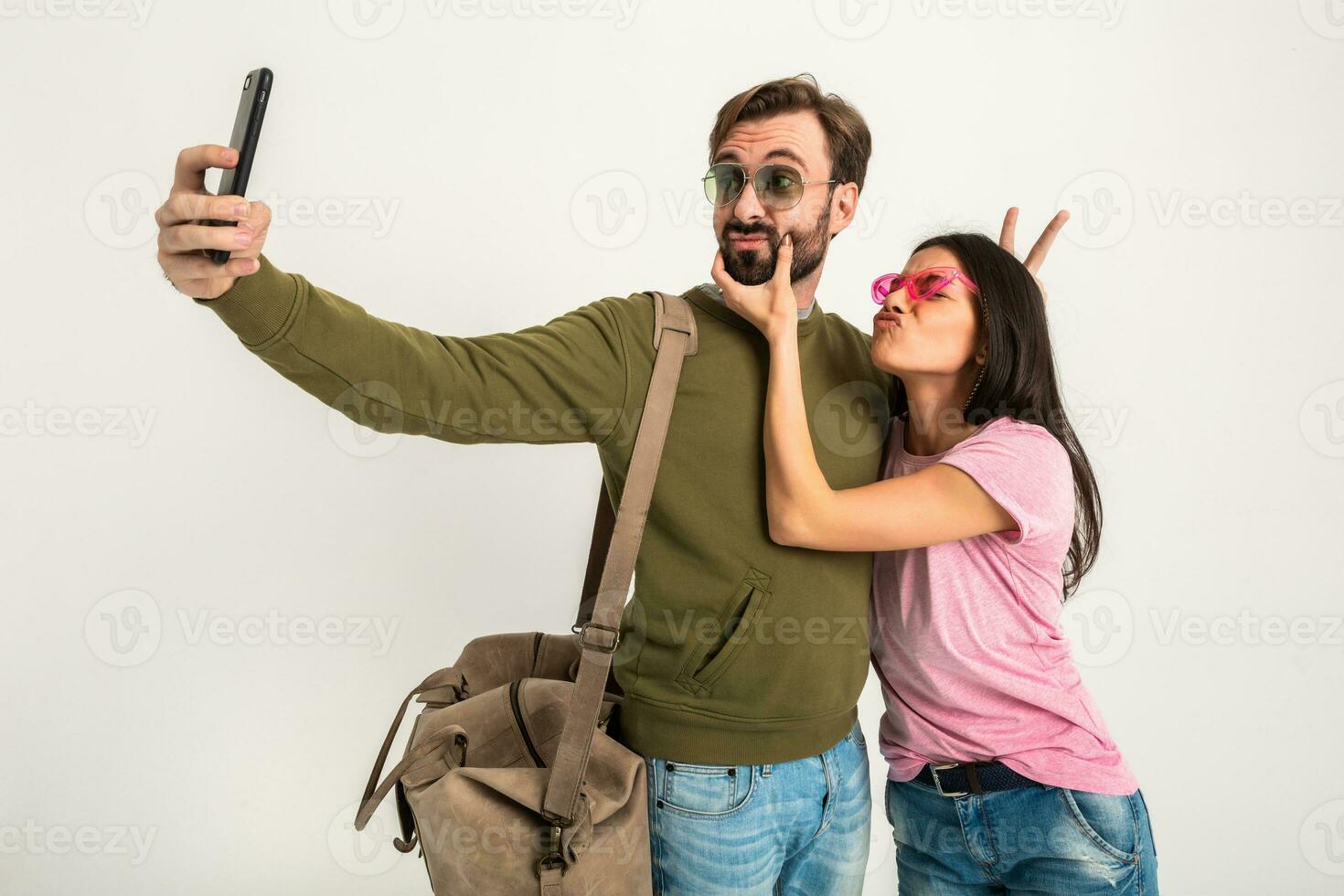 couple smiling woman and man in sweatshirt with travel bag photo