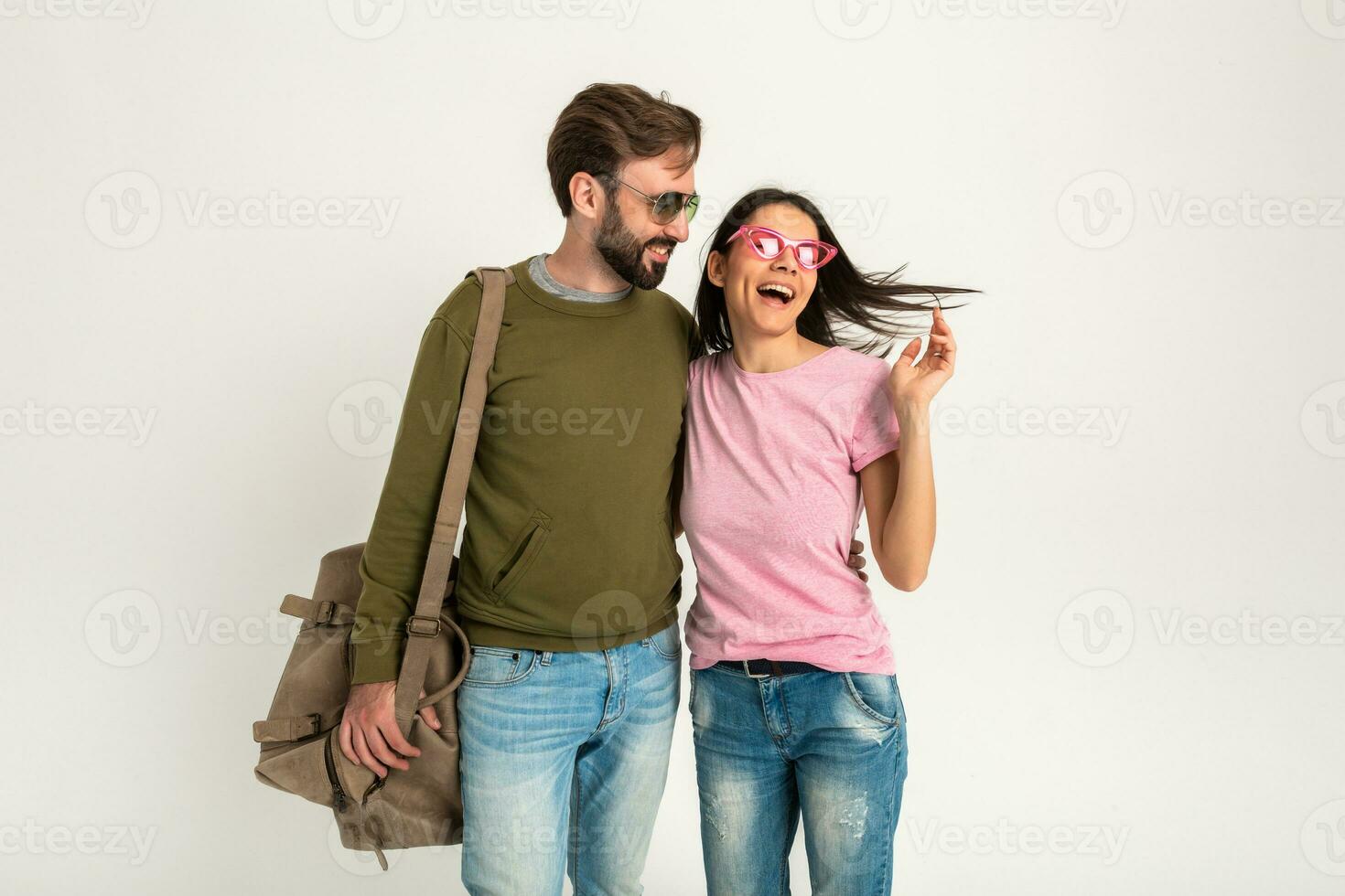 couple smiling woman and man in sweatshirt with travel bag photo