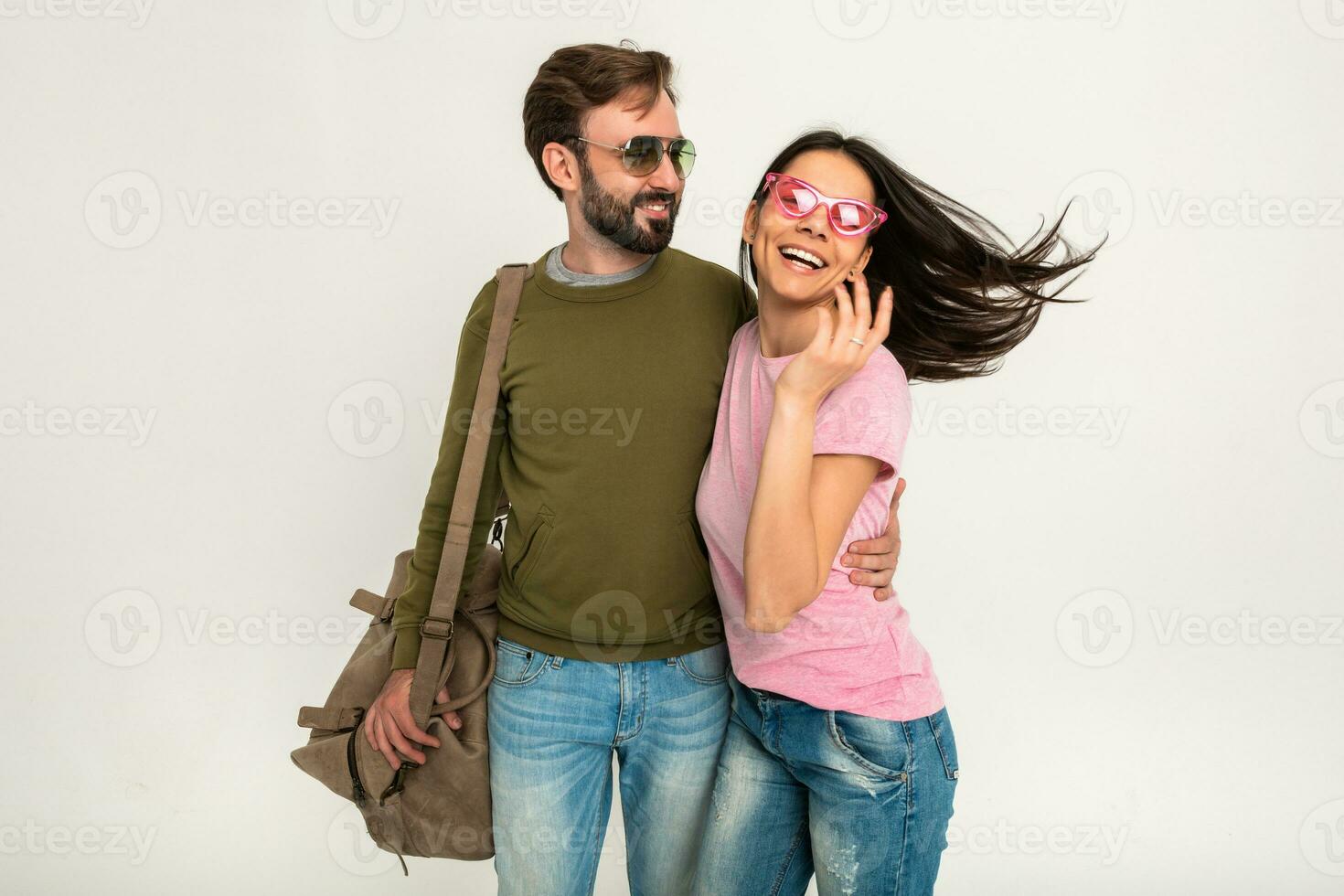 couple smiling woman and man in sweatshirt with travel bag photo