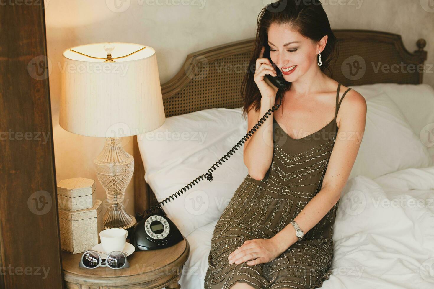 joven hermosa mujer sentado en cama en hotel habitación foto