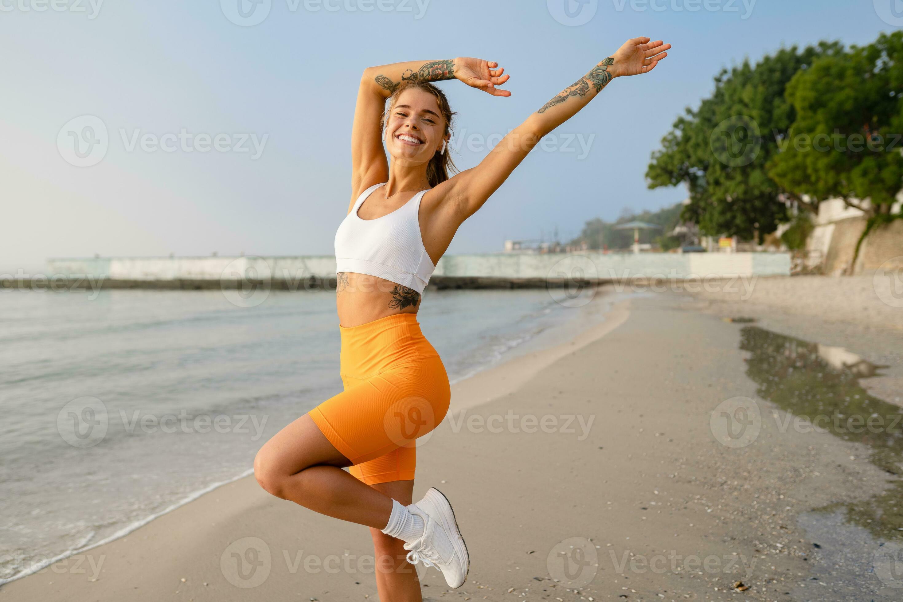 Fotografia do Stock: Stylish fit woman in sport outfit walking on sport  square. Attractive sportswoman, enjoying summer, training, outwork,  happiness