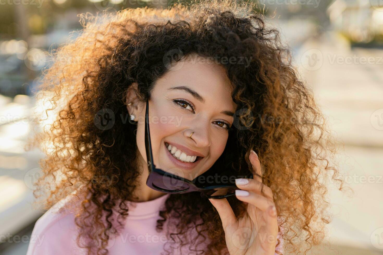 young pretty curly woman in sunglasses on summer vacation photo