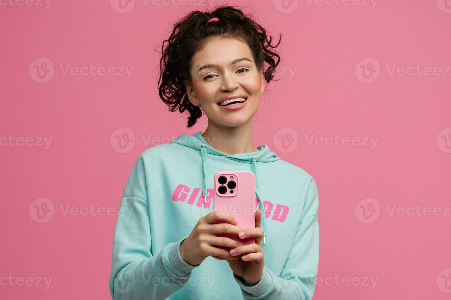 sonriente contento hermosa mujer en elegante Deportes atuendo posando en rosado antecedentes aislado en estudio foto