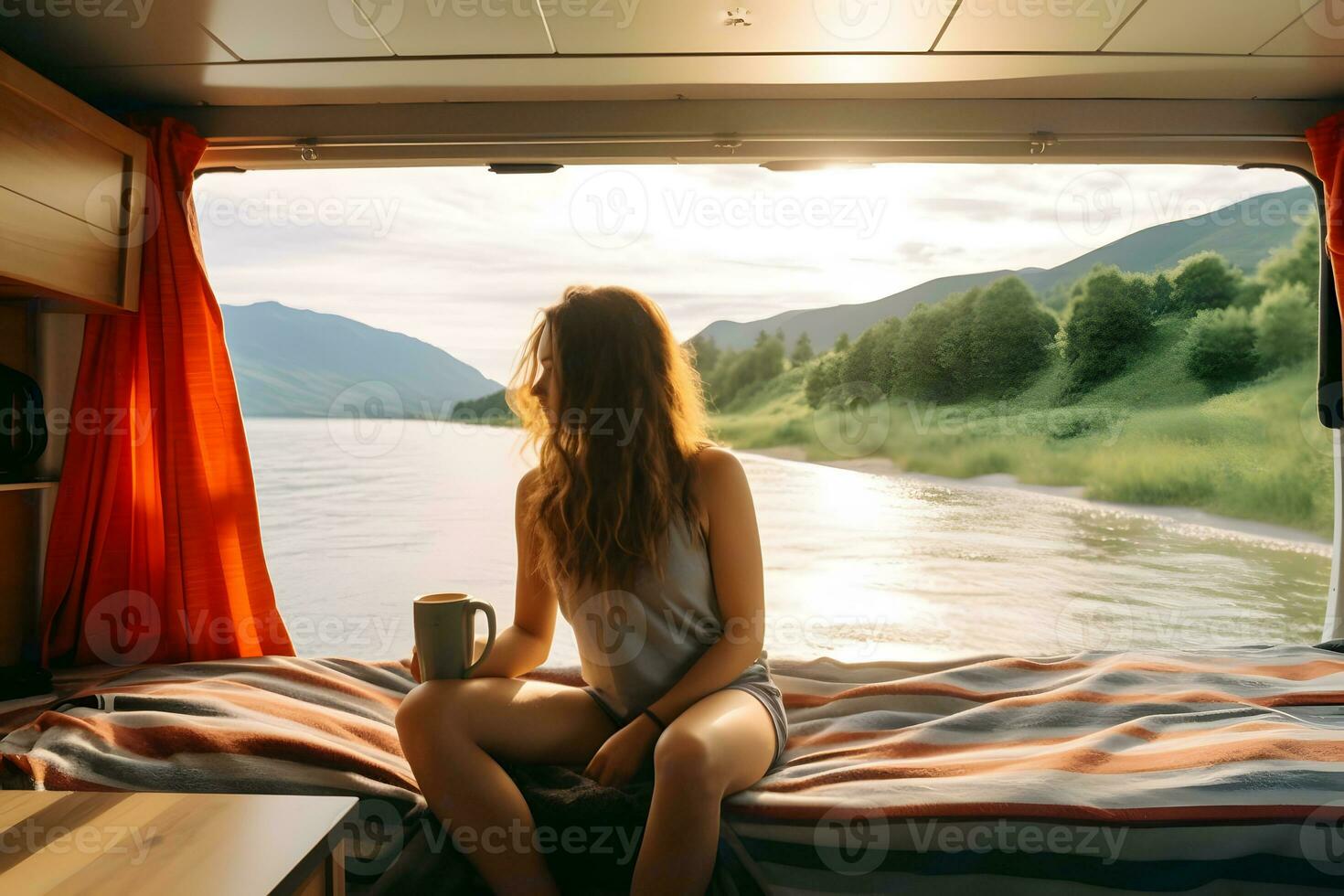 Camper girl holding coffee cup inside camper van at riverside. photo