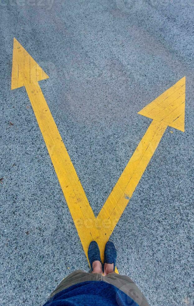 Deciding which way to walk following the signs on the paved road photo