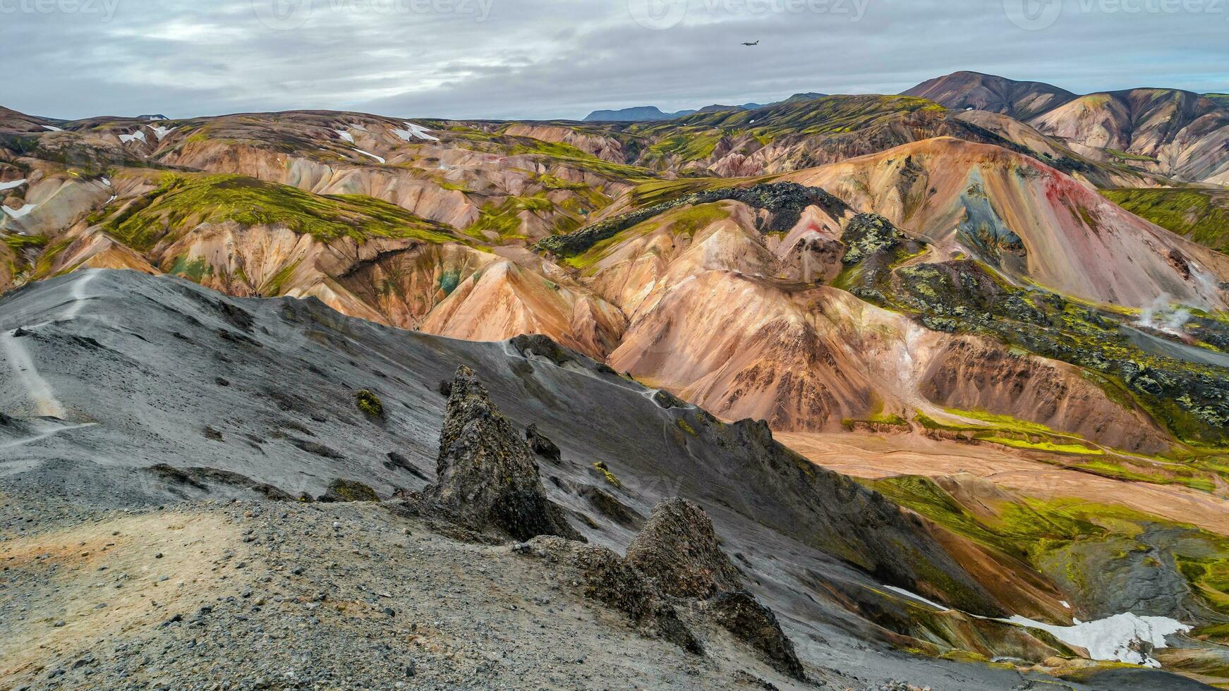 Beautiful panoramic Icelandic landscape of colorful rainbow volcanic Landmannalaugar mountains, at famous Laugavegur hiking trail with dramatic snowy sky, and red volcano soil in Iceland. photo