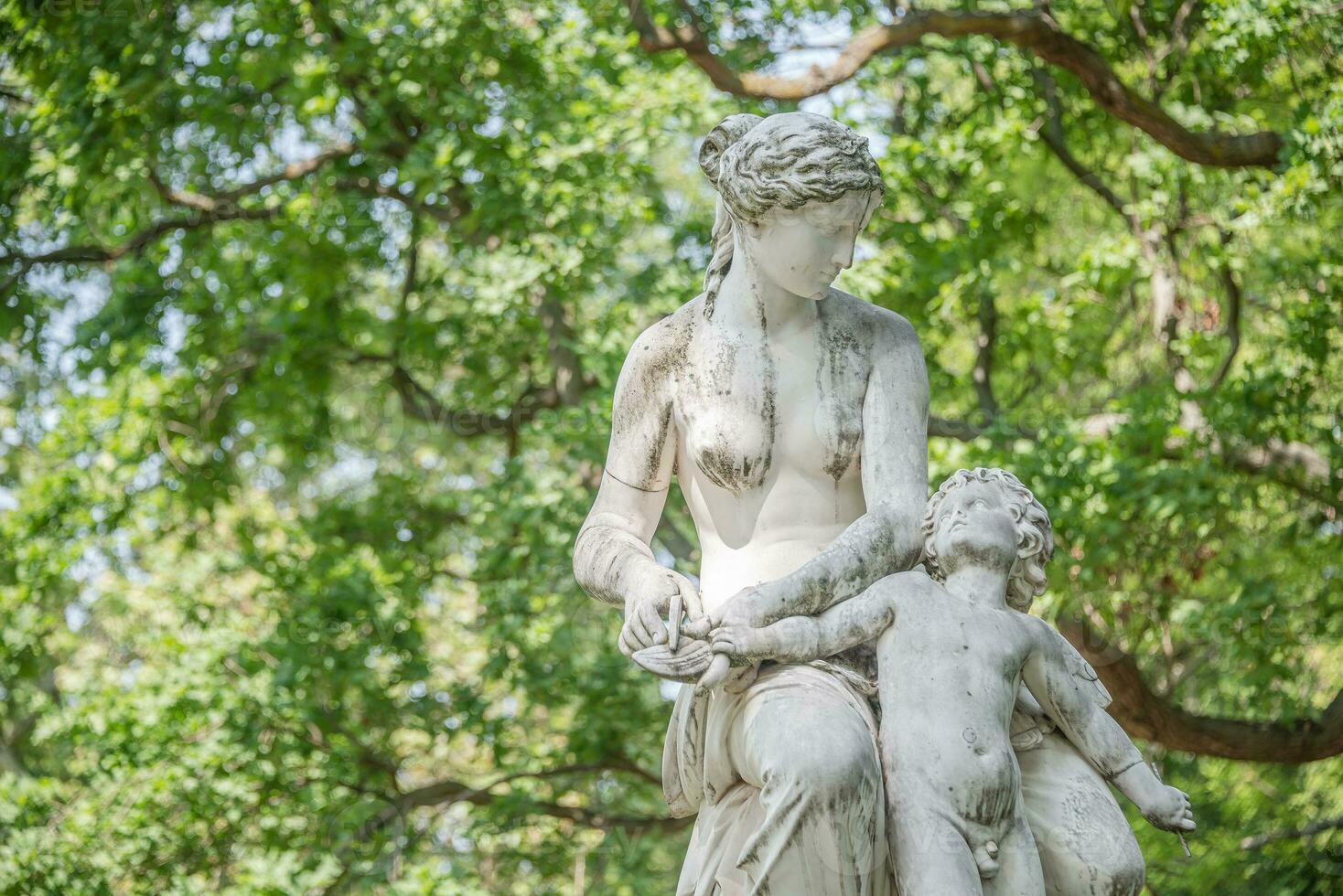 Dresden, Germany -  Statue of Venus and child in the citizen meadow park called Burgerwiese. Cityscape of the downtown at sunny Spring day and blue sky. photo