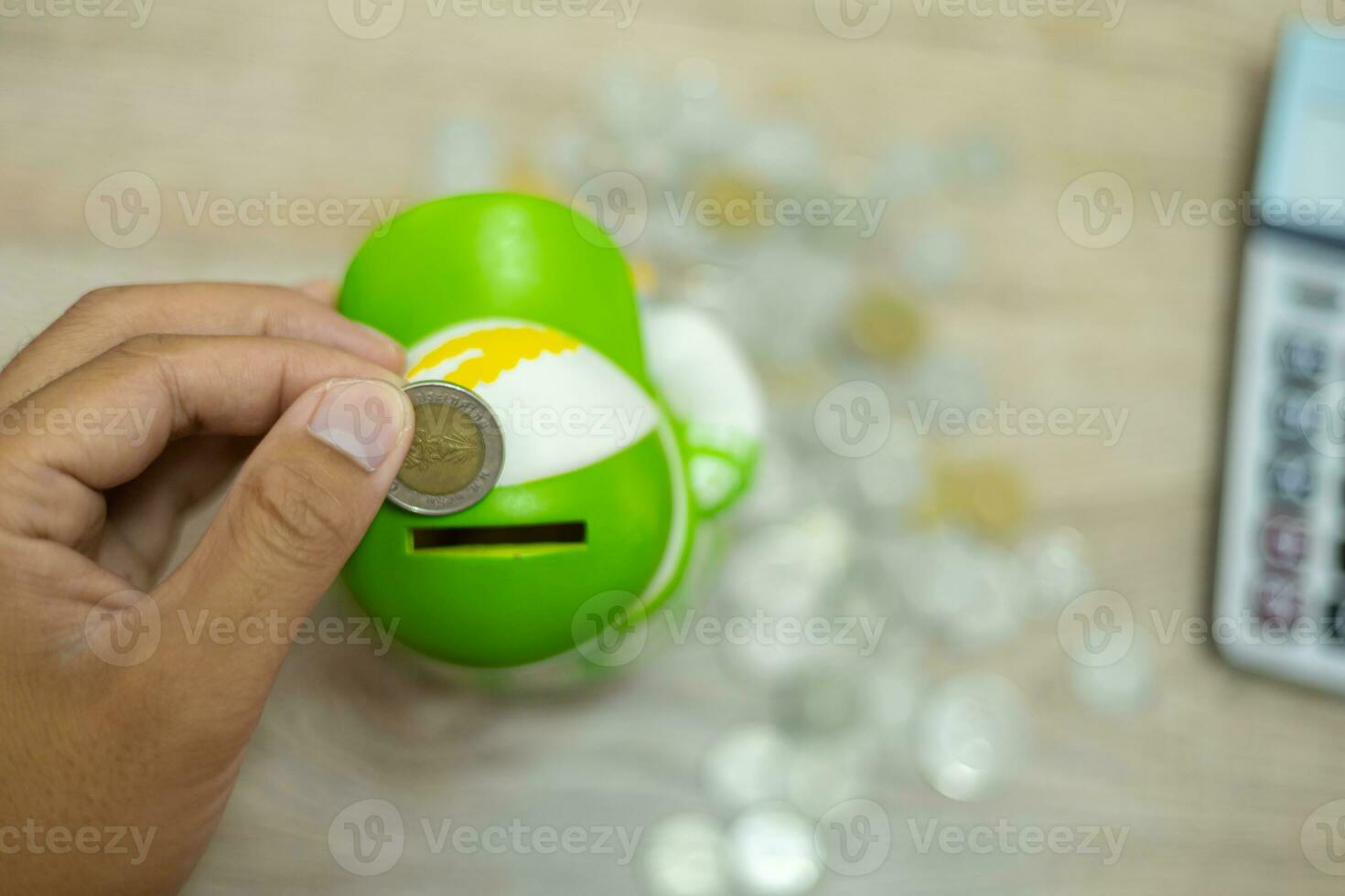 Cropped view of businessman's hands doing calculations and putting coins in pig bank to save money, finance concept photo