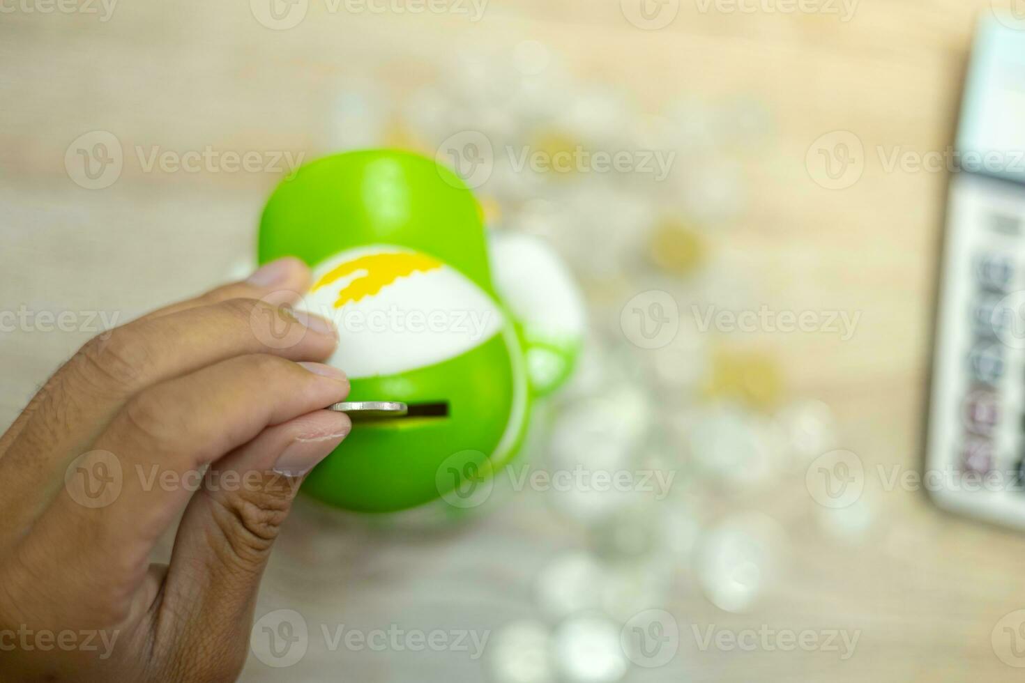 Cropped view of businessman's hands doing calculations and putting coins in pig bank to save money, finance concept photo