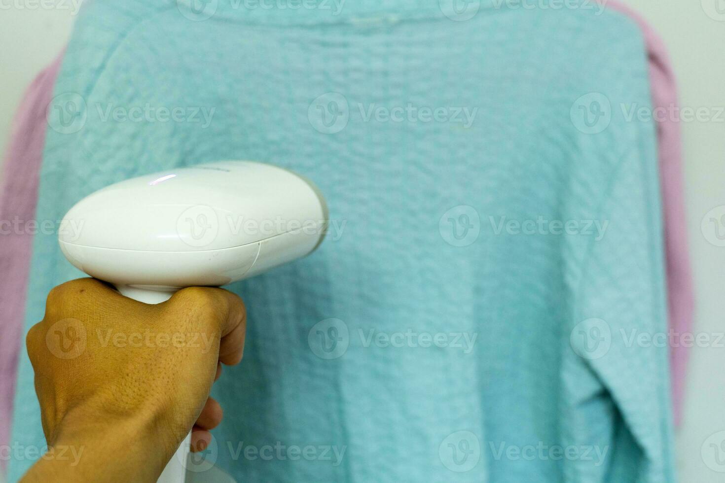 Woman ironing clothes with a steam iron photo