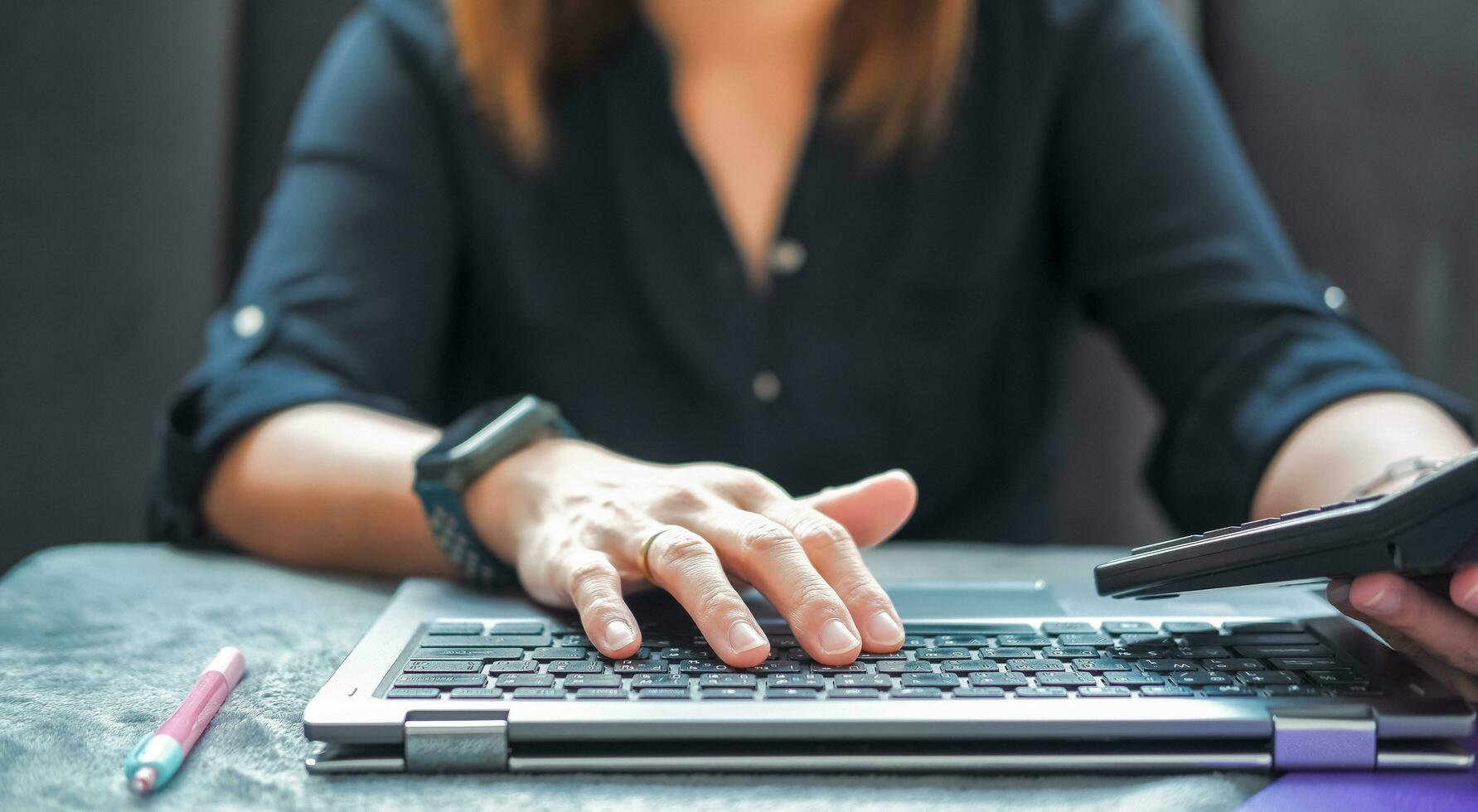 a woman using a calculator to analyze data Suitable for making infographics. photo