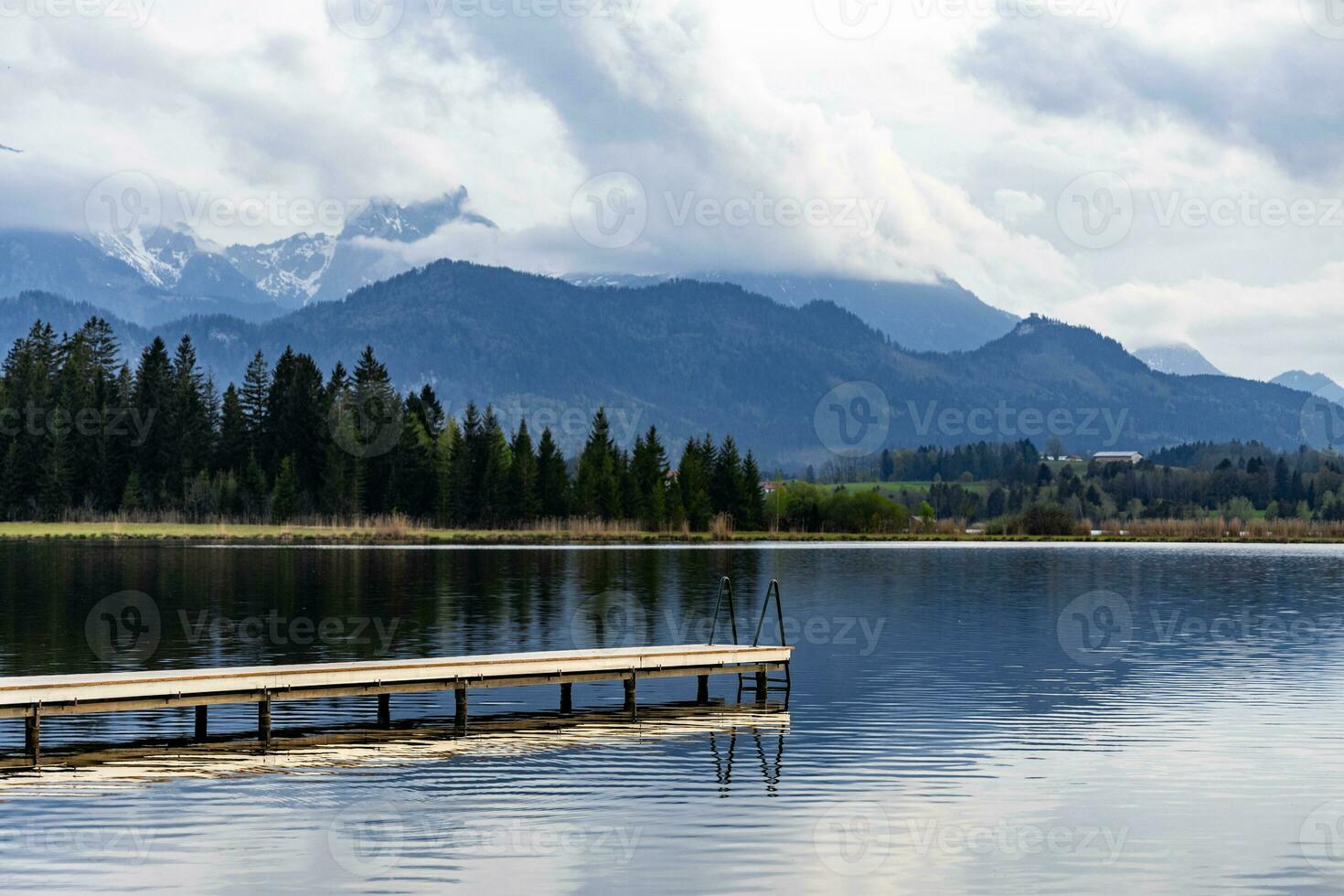 Tranquil landscape featuring an empty dock at a mountain lake in Bavarian Alps, Germany. photo