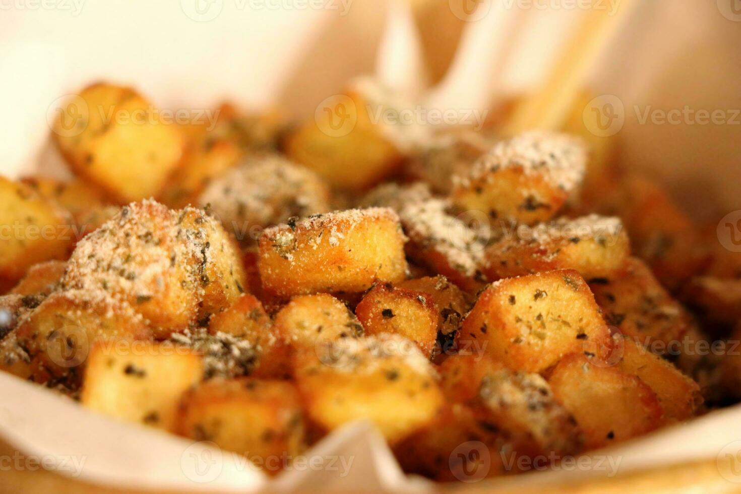 French fries or fried potatoes cubes sprinkled with cheese, Take a close-up photo of the wallpaper.