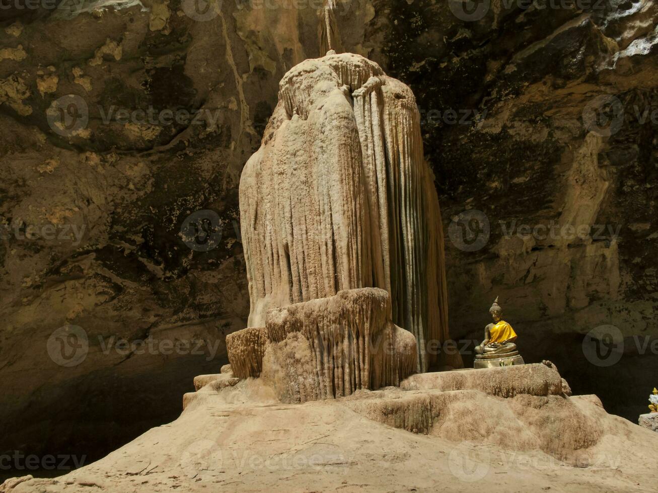 There are stalactites in the cave, there is a Buddha image inventing the conjunction on the side. photo