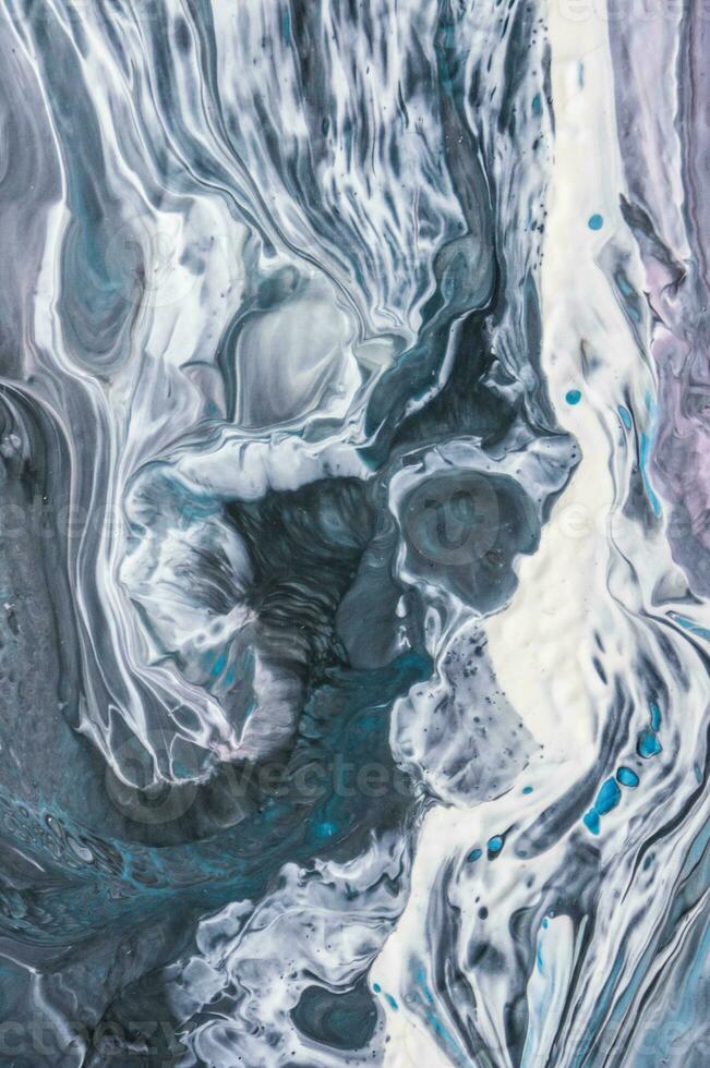 Abstract created using the technique of liquid acrylic. Macro photography of the smallest details of a picture. The picture shows how overflows of shades and colors of paint resemble space motifs. photo