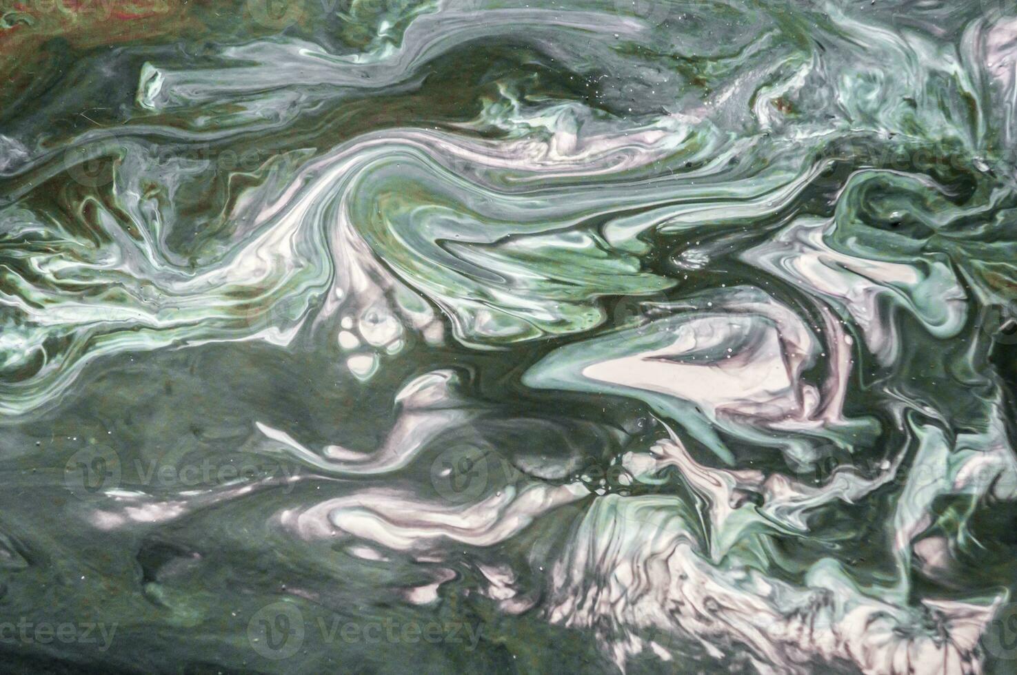Abstract created using the technique of liquid acrylic. Macro photography of the smallest details of a picture. The picture shows how overflows of shades and colors of paint resemble space motifs. photo