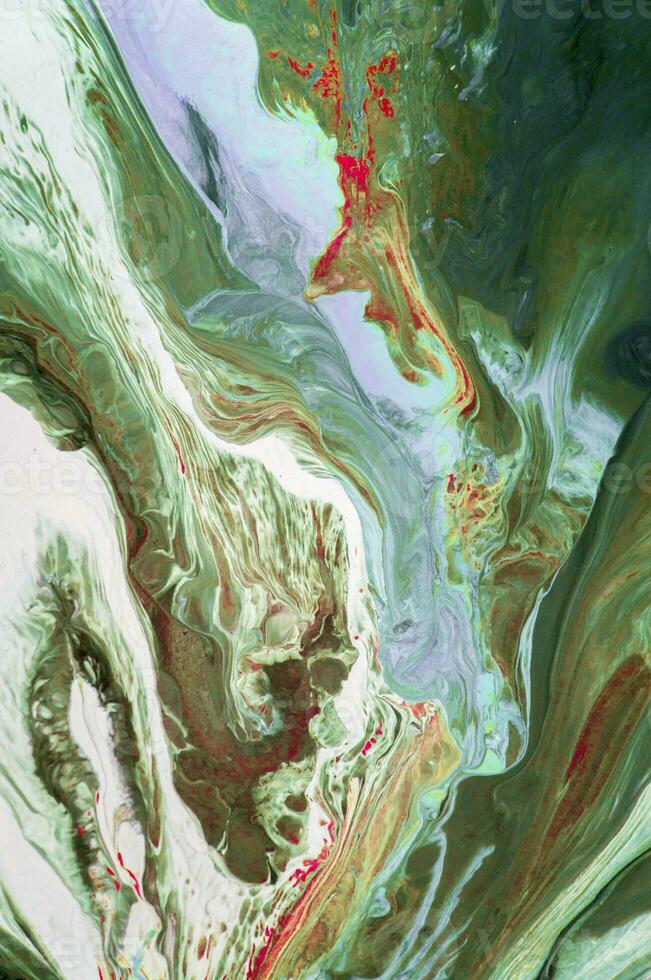 Abstract created using the technique of liquid acrylic. Macro photography of the smallest details of a picture. The picture shows how overflows of shades and colors of paint resemble space motifs. photo