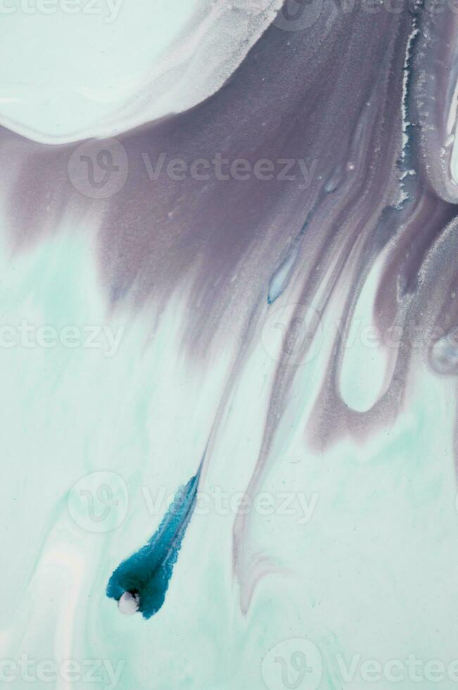 Abstract created using the technique of liquid acrylic. Macro photography of the smallest details of a panting. The panting shows how overflows of shades and colors of paint resemble space motifs. photo