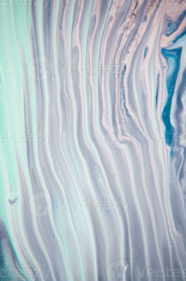 Abstract created using the technique of liquid acrylic. Macro photography of the smallest details of a panting. The panting shows how overflows of shades and colors of paint resemble space motifs. photo