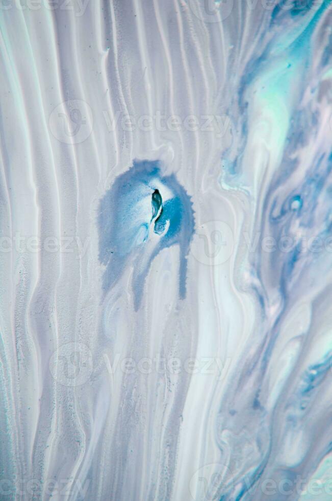 Abstract created using the technique of liquid acrylic. Macro photography of the smallest details of a panting. The panting shows how overflows of shades and colors of paint resemble space motifs. photo