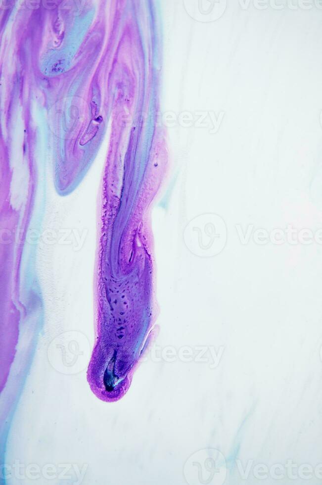 Abstract created using the technique of liquid acrylic. Macro photography of the smallest details of a panting. The panting shows how overflows of shades and colors of paint resemble space motifs. photo