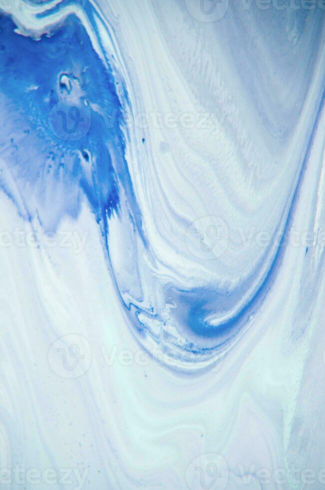 Abstract created using the technique of liquid acrylic. Macro photography of the smallest details of a panting. The panting shows how overflows of shades and colors of paint resemble space motifs. photo