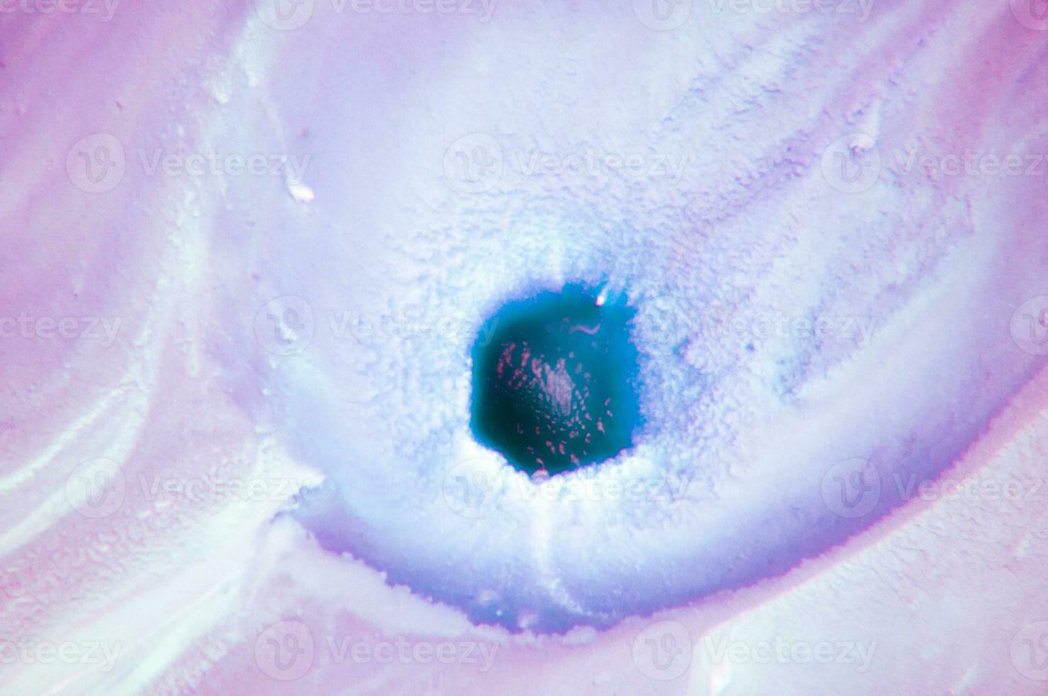 Abstract created using the technique of liquid acrylic. Macro photography of the smallest details of a panting. The panting shows how overflows of shades and colors of paint resemble space motifs. photo