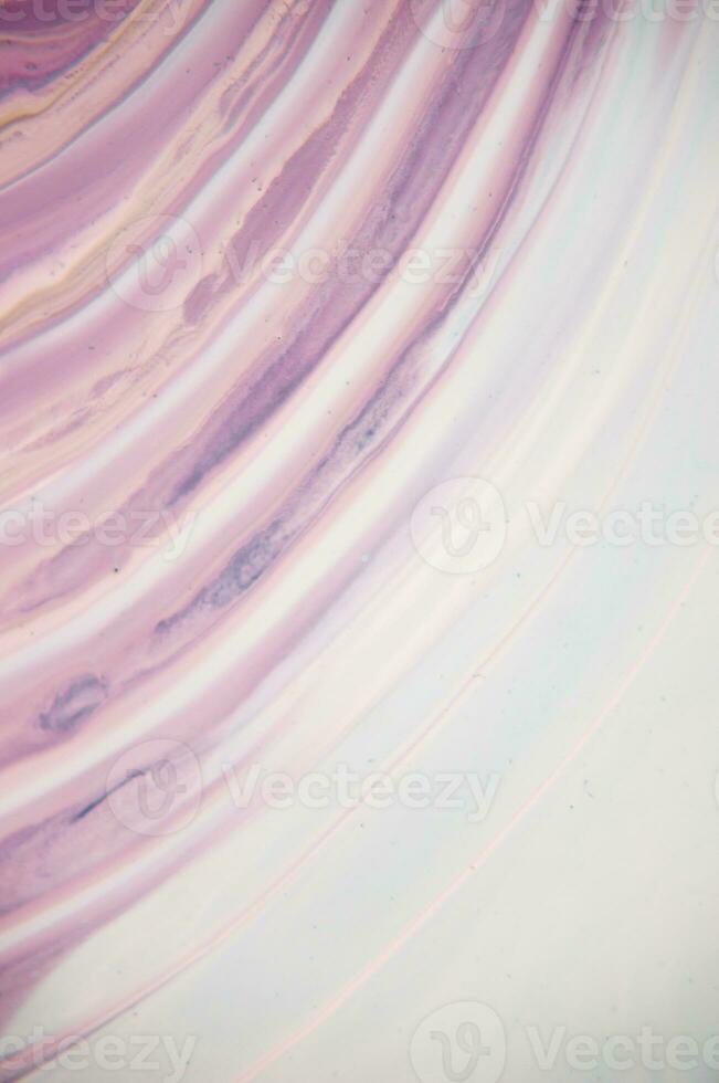 Abstract created using the technique of liquid acrylic. Macro photography of the smallest details of a panting. The panting shows how overflows of shades and colors of paint resemble space motifs. photo