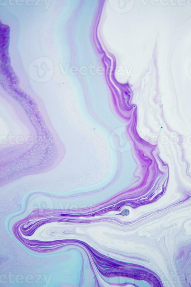 Abstract created using the technique of liquid acrylic. Macro photography of the smallest details of a panting. The panting shows how overflows of shades and colors of paint resemble space motifs. photo
