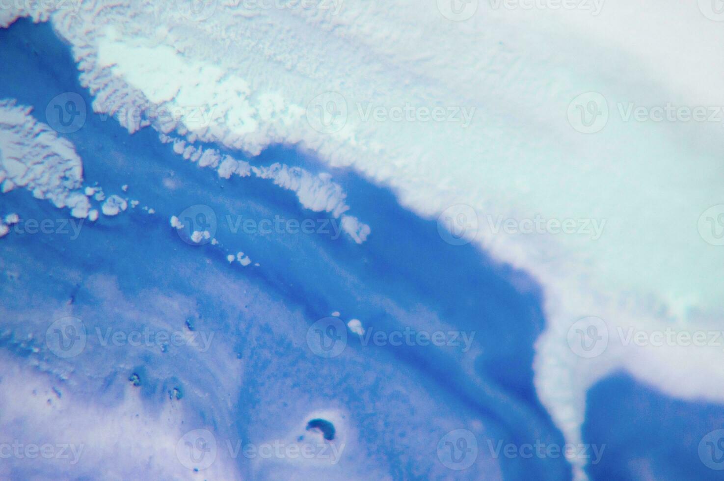 Abstract created using the technique of liquid acrylic. Macro photography of the smallest details of a panting. The panting shows how overflows of shades and colors of paint resemble space motifs. photo