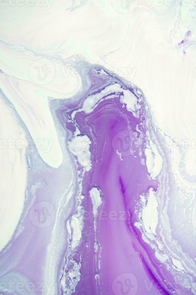 Abstract created using the technique of liquid acrylic. Macro photography of the smallest details of a panting. The panting shows how overflows of shades and colors of paint resemble space motifs. photo