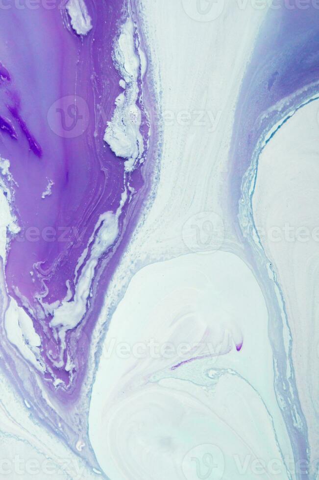 Abstract created using the technique of liquid acrylic. Macro photography of the smallest details of a panting. The panting shows how overflows of shades and colors of paint resemble space motifs. photo