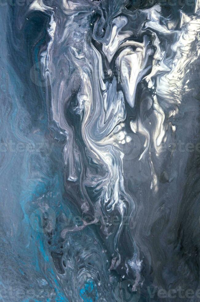 Abstract created using the technique of liquid acrylic. Macro photography of the smallest details of a picture. The picture shows how overflows of shades and colors of paint resemble space motifs. photo