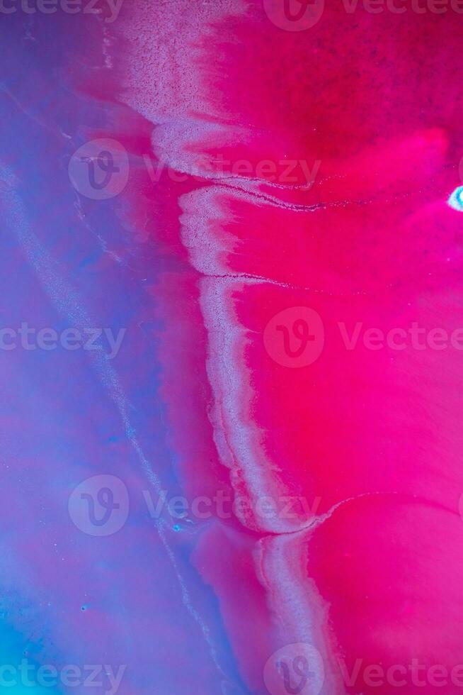 Abstract created using the technique of liquid acrylic. Macro photography of the smallest details of a panting. The panting shows how overflows of shades and colors of paint resemble space motifs. photo