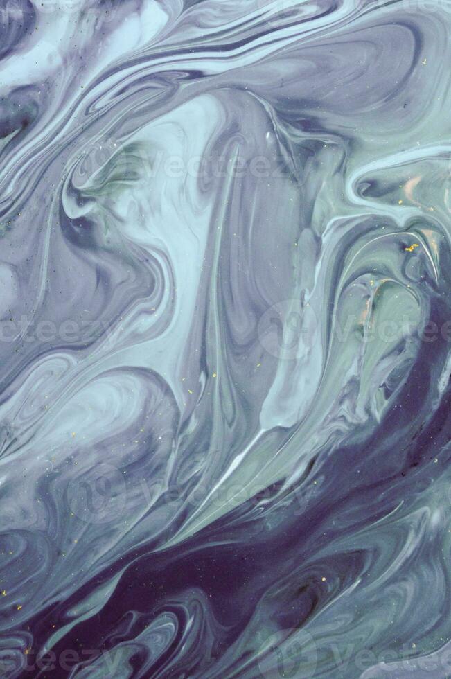 Abstract created using the technique of liquid acrylic. Macro photography of the smallest details of a panting. The panting shows how overflows of shades and colors of paint resemble space motifs. photo