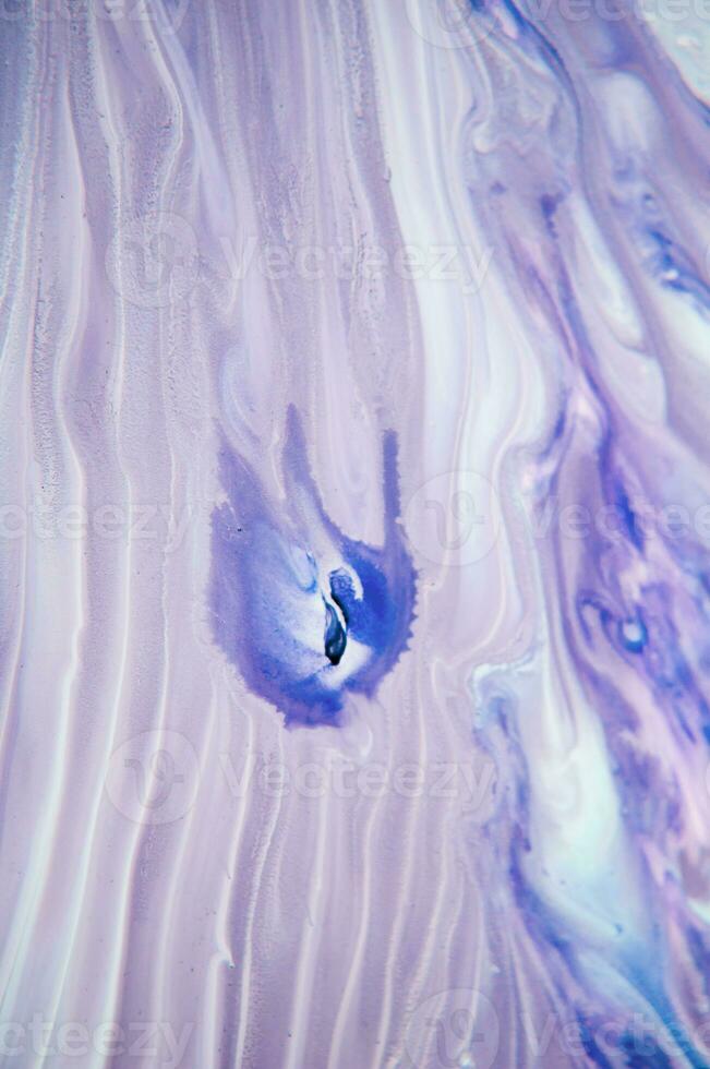 Abstract created using the technique of liquid acrylic. Macro photography of the smallest details of a panting. The panting shows how overflows of shades and colors of paint resemble space motifs. photo