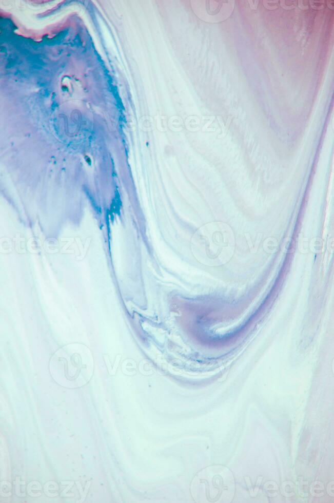 Abstract created using the technique of liquid acrylic. Macro photography of the smallest details of a panting. The panting shows how overflows of shades and colors of paint resemble space motifs. photo