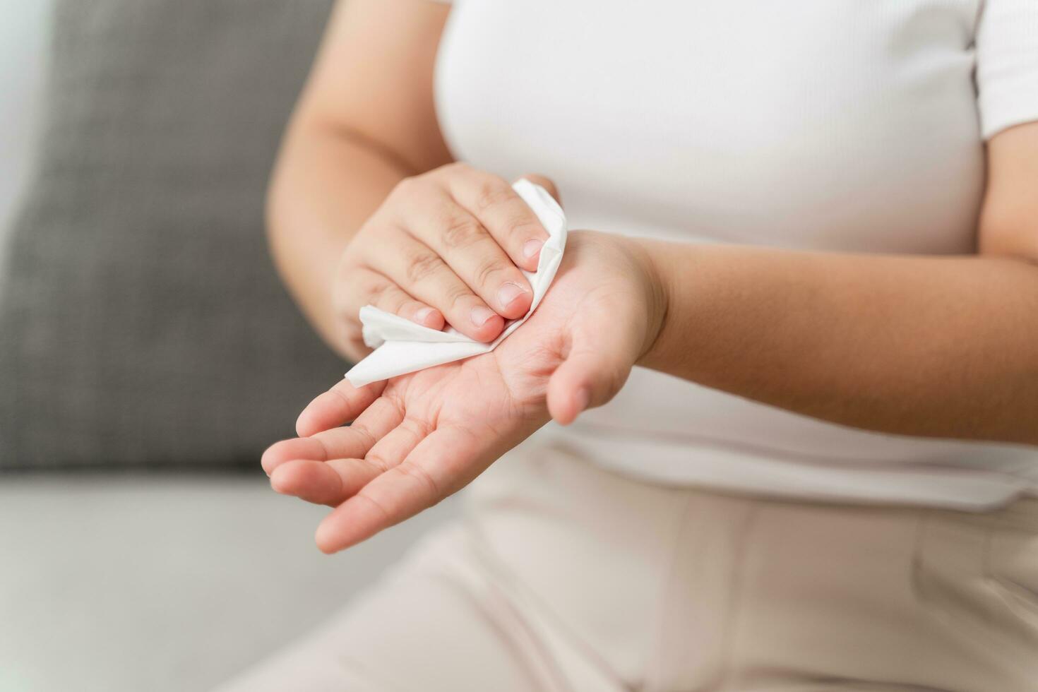 Woman wipes cleaning her hand with a tissue paper towel. Healthcare and medical concept. photo