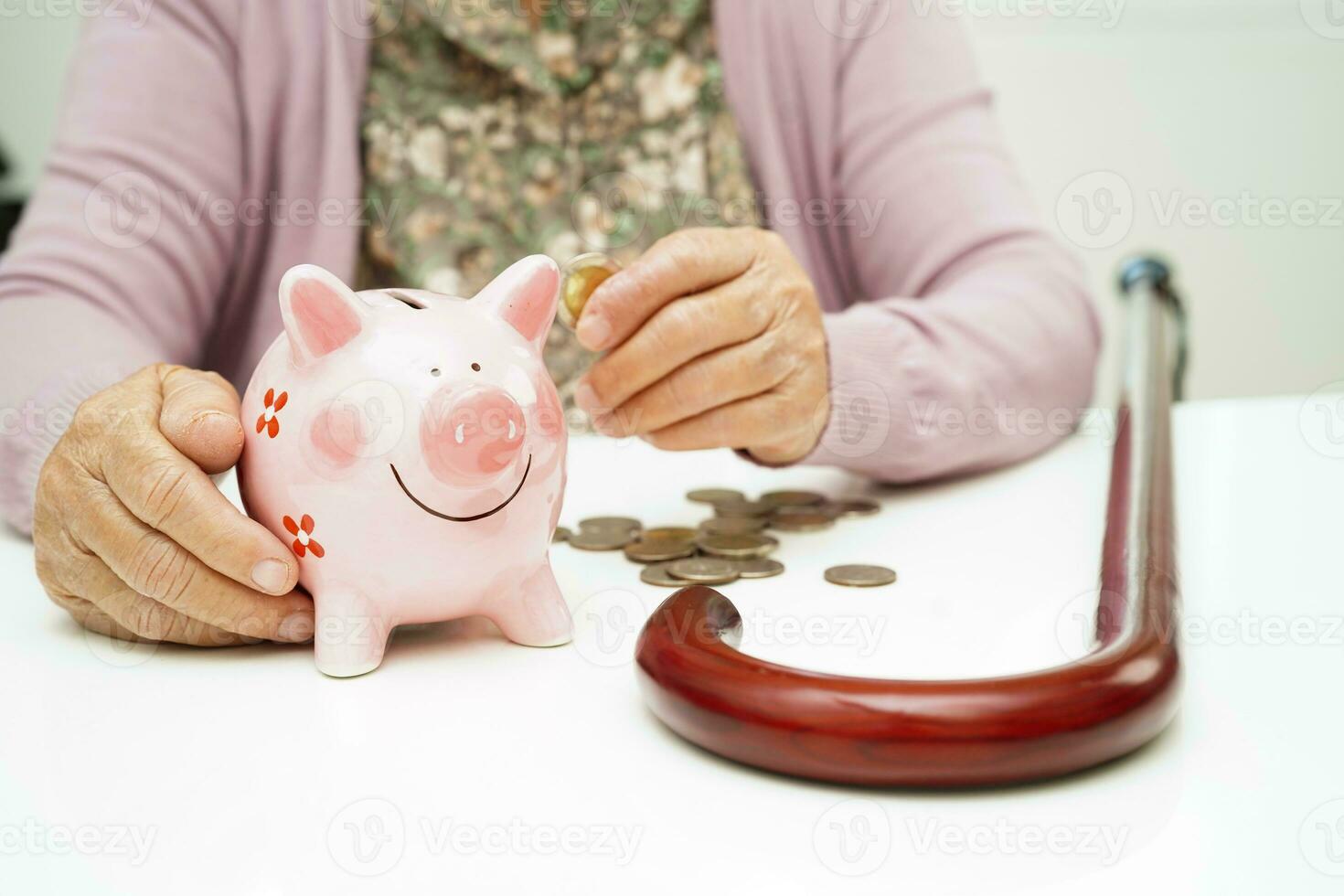 Retired elderly woman putting coins money in piggy bank and worry about monthly expenses and treatment fee payment. photo