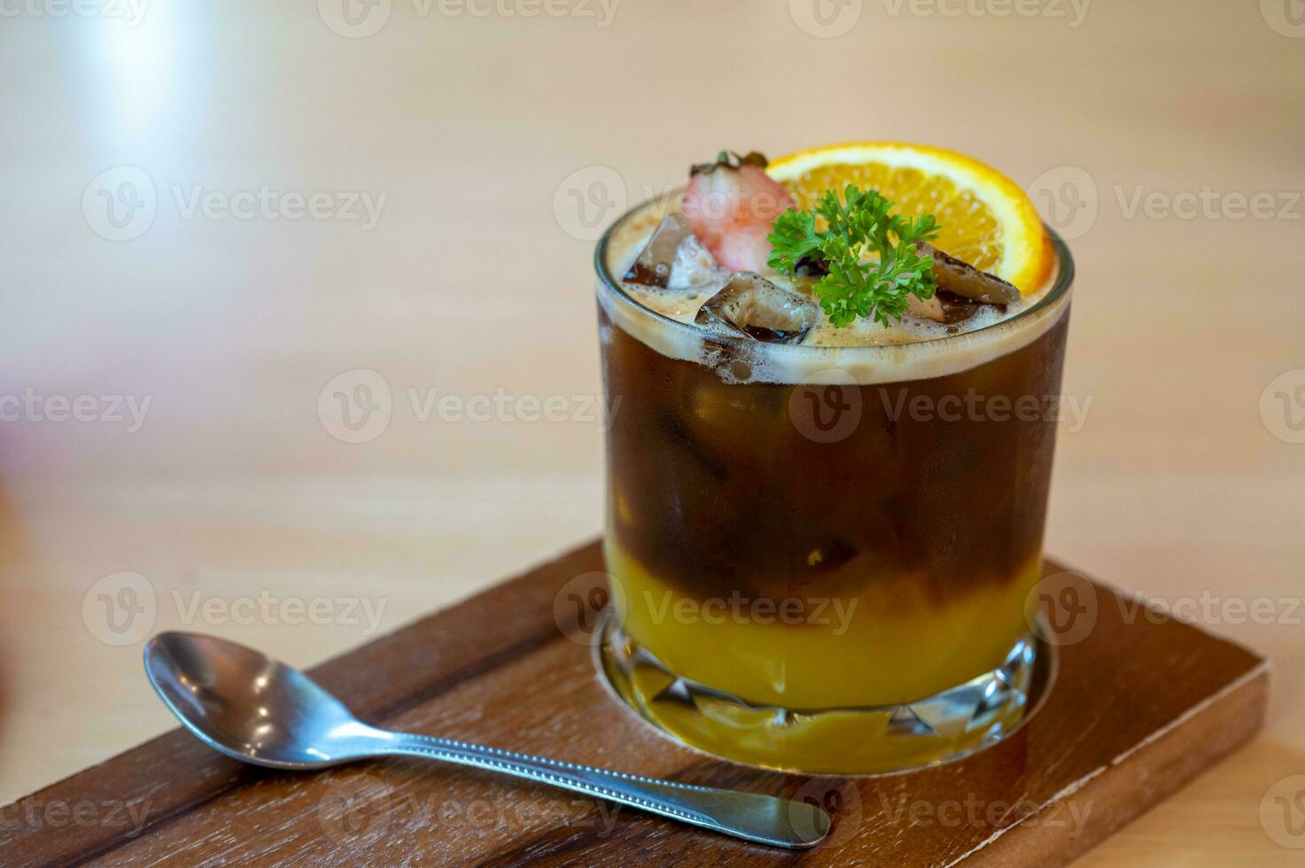 A glass of iced americano black coffee and layer of orange with sliced orange fruit photo