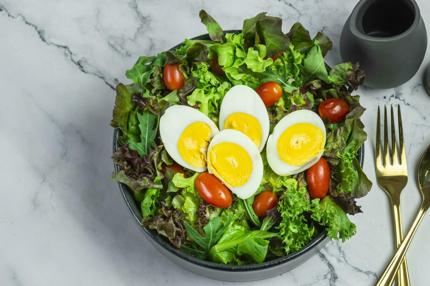 a bowl of salad with eggs, tomatoes and lettuce photo