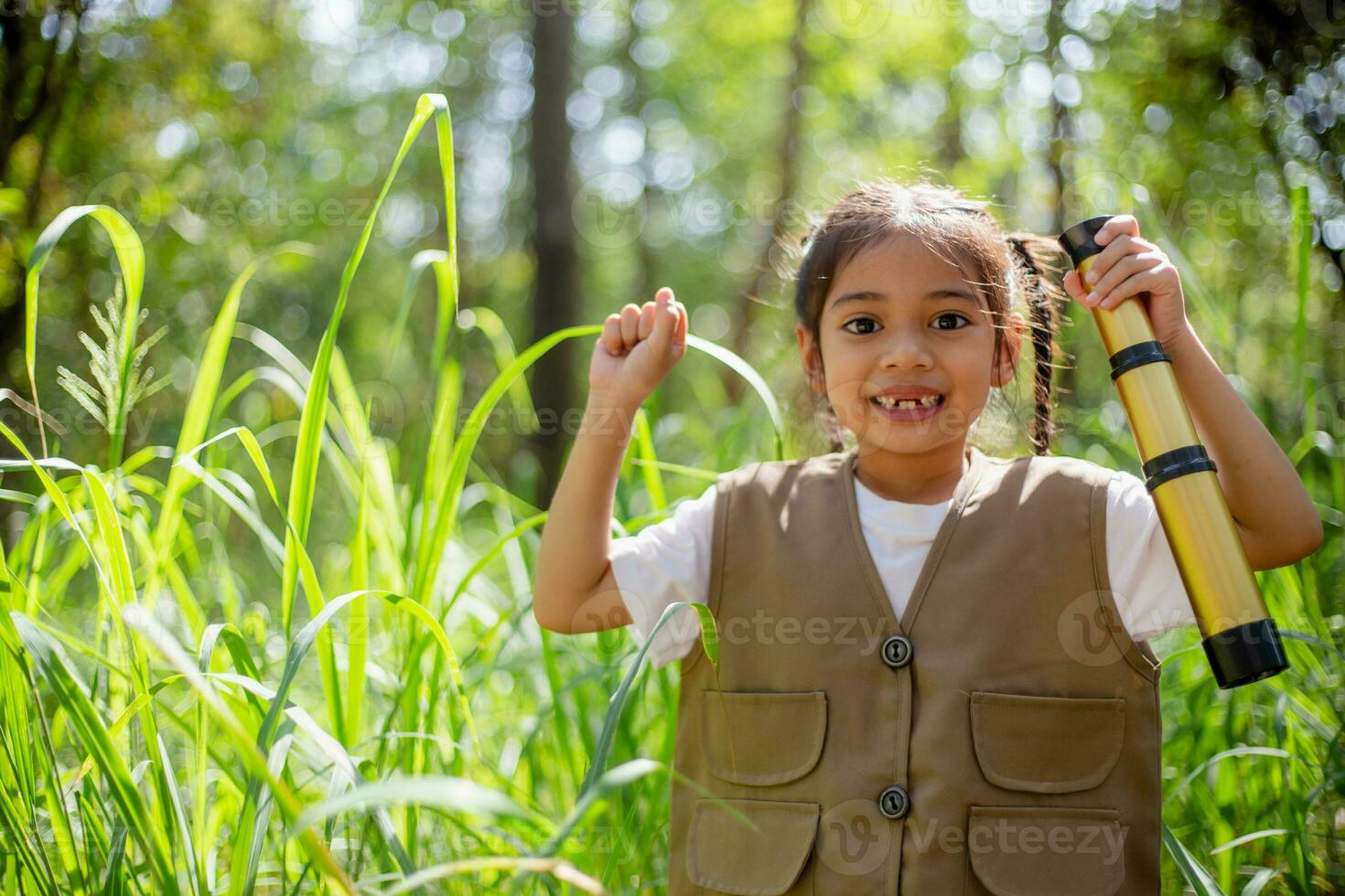 Asian little girls explore nature through magnifying glasses and binoculars in the park. Education, field trips, research, and discovery concepts. photo