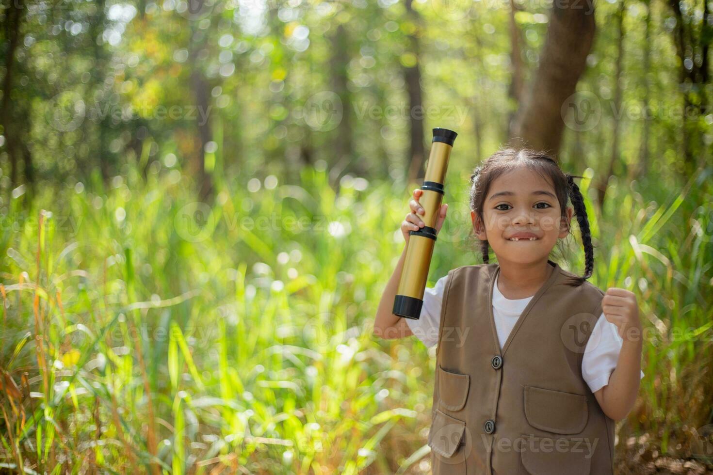 Asian little girls explore nature through magnifying glasses and binoculars in the park. Education, field trips, research, and discovery concepts. photo