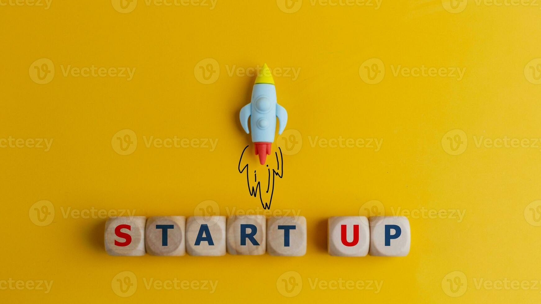 Start up concept. A symbol of a quick start of a new project in business. Rocket and cubes with text Start up on a yellow background. photo