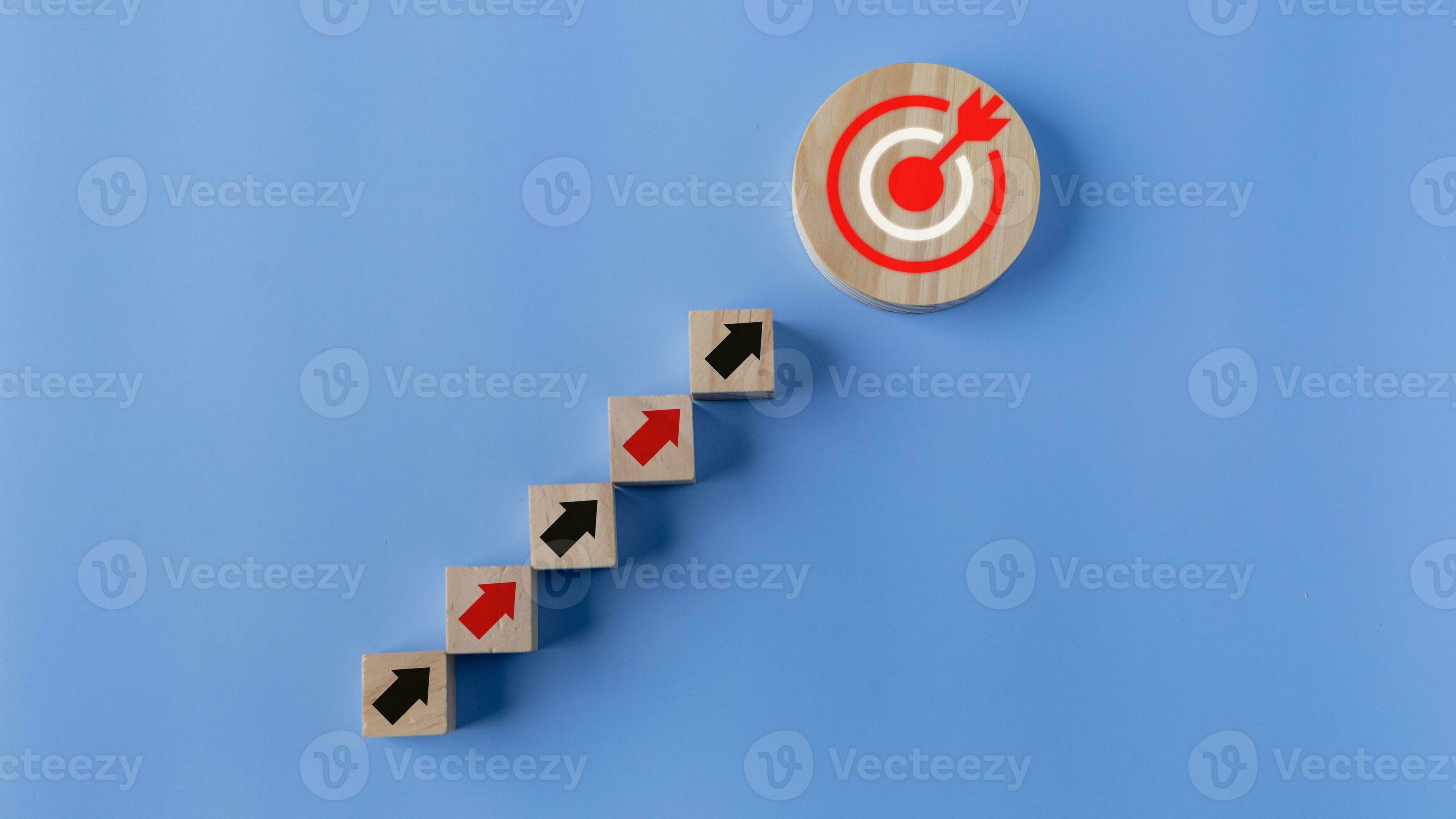 Wooden blocks with arrow and target on blue background. Success concept