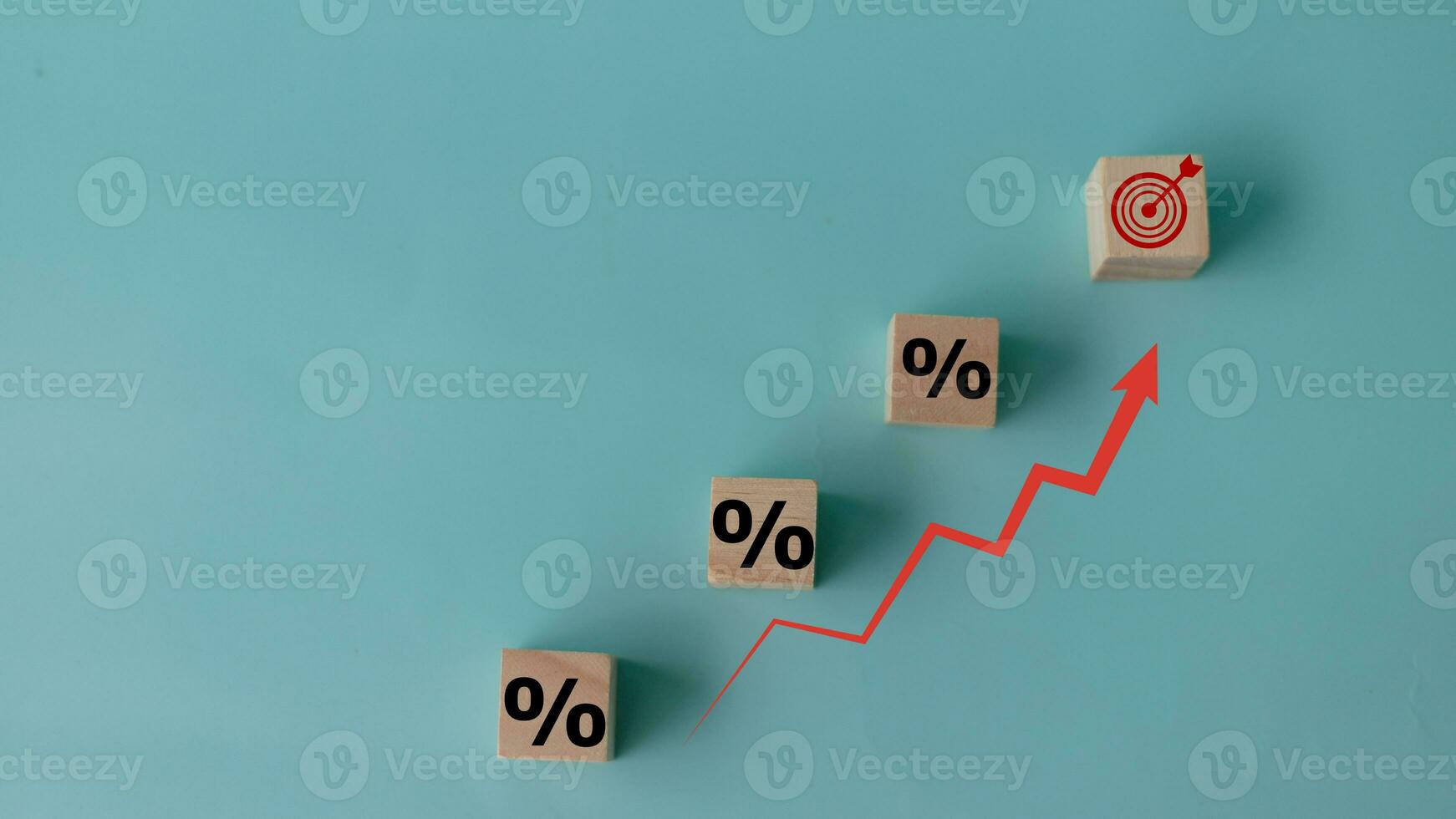 Concept of increasing sales. Wooden cubes with percentage icon and Rising arrow red on blue background. investment growth goals concept. photo