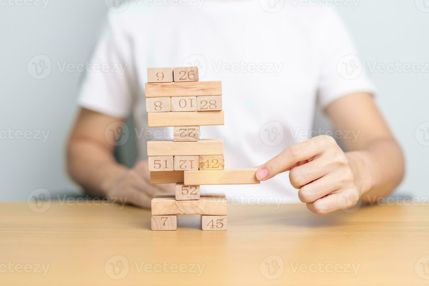 hand pulling wooden block tower on table. Business planning, Risk Management, Solution, leader, strategy, Crisis, falling Business, and Economic recession concept photo